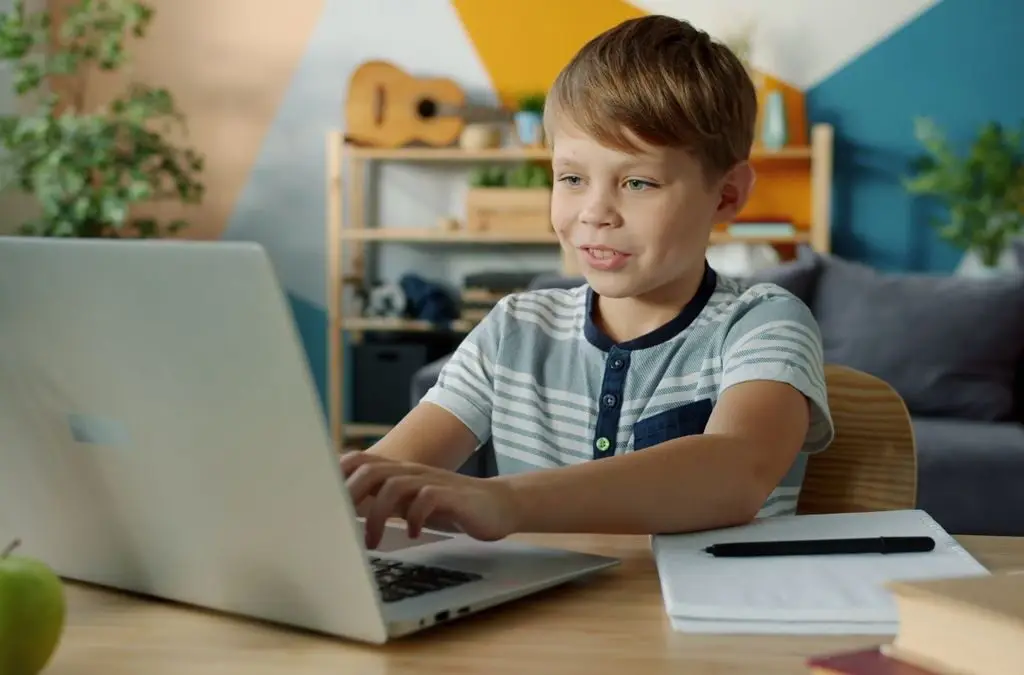 Child attending a live online Quran class on a laptop at home