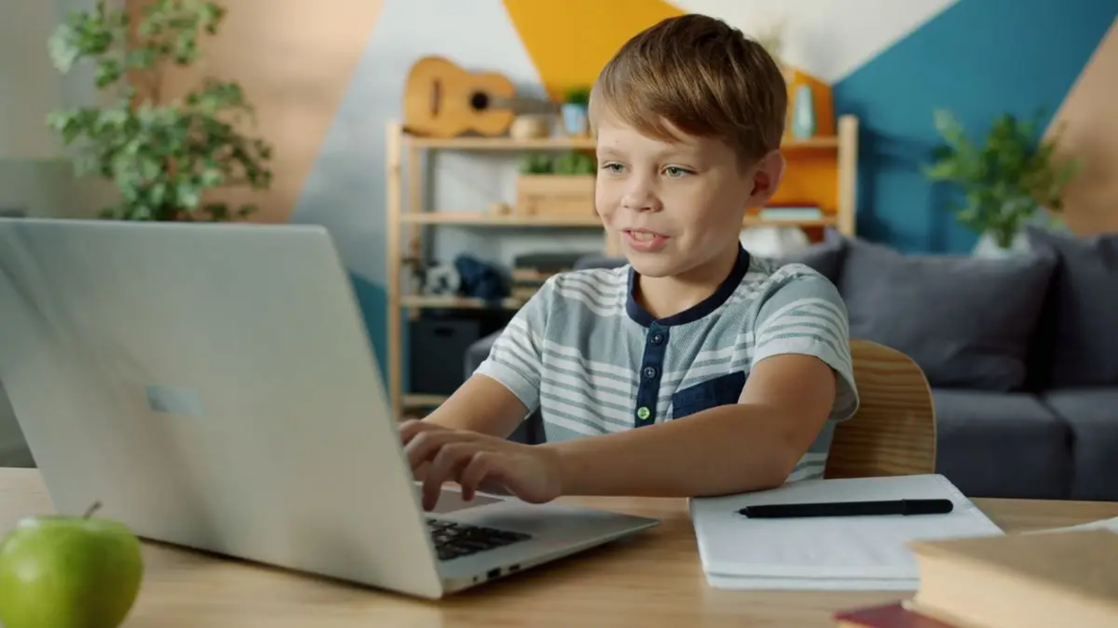 Child attending a live online Quran class on a laptop at home