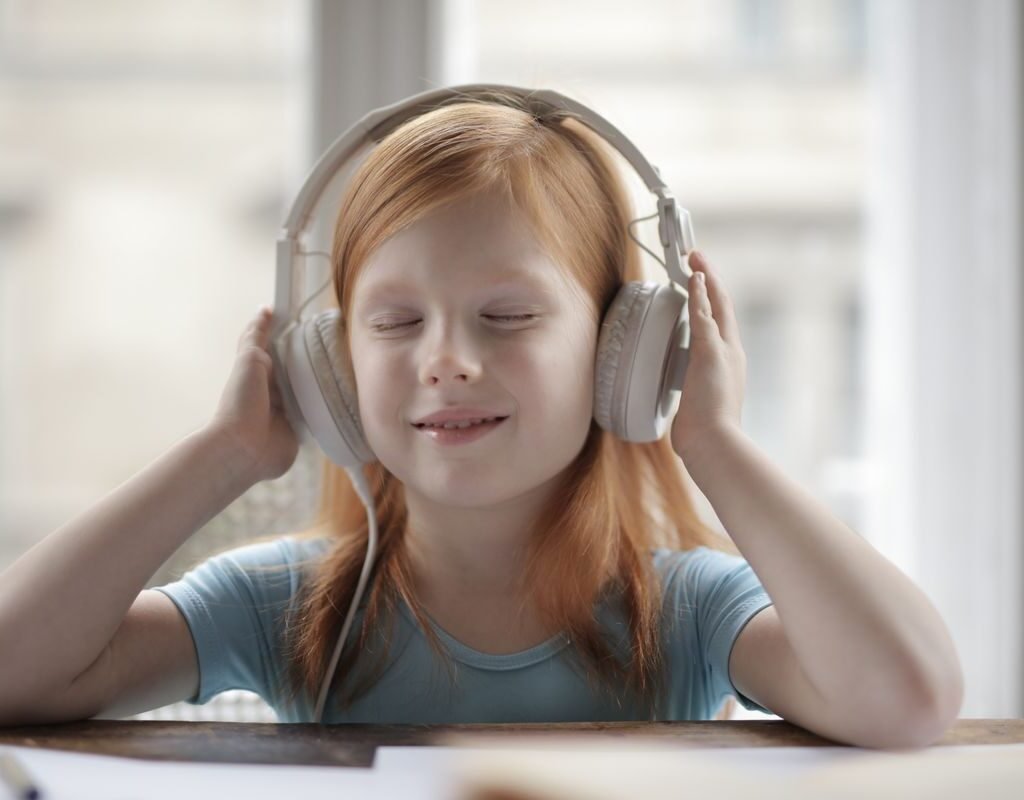 Child wearing headphones for a live one-on-one online Quran class