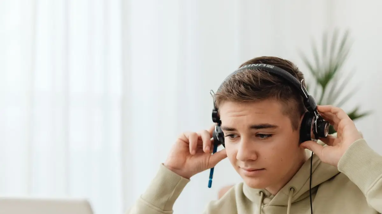 Boy using a laptop with headphones for an online Quran lesson after school